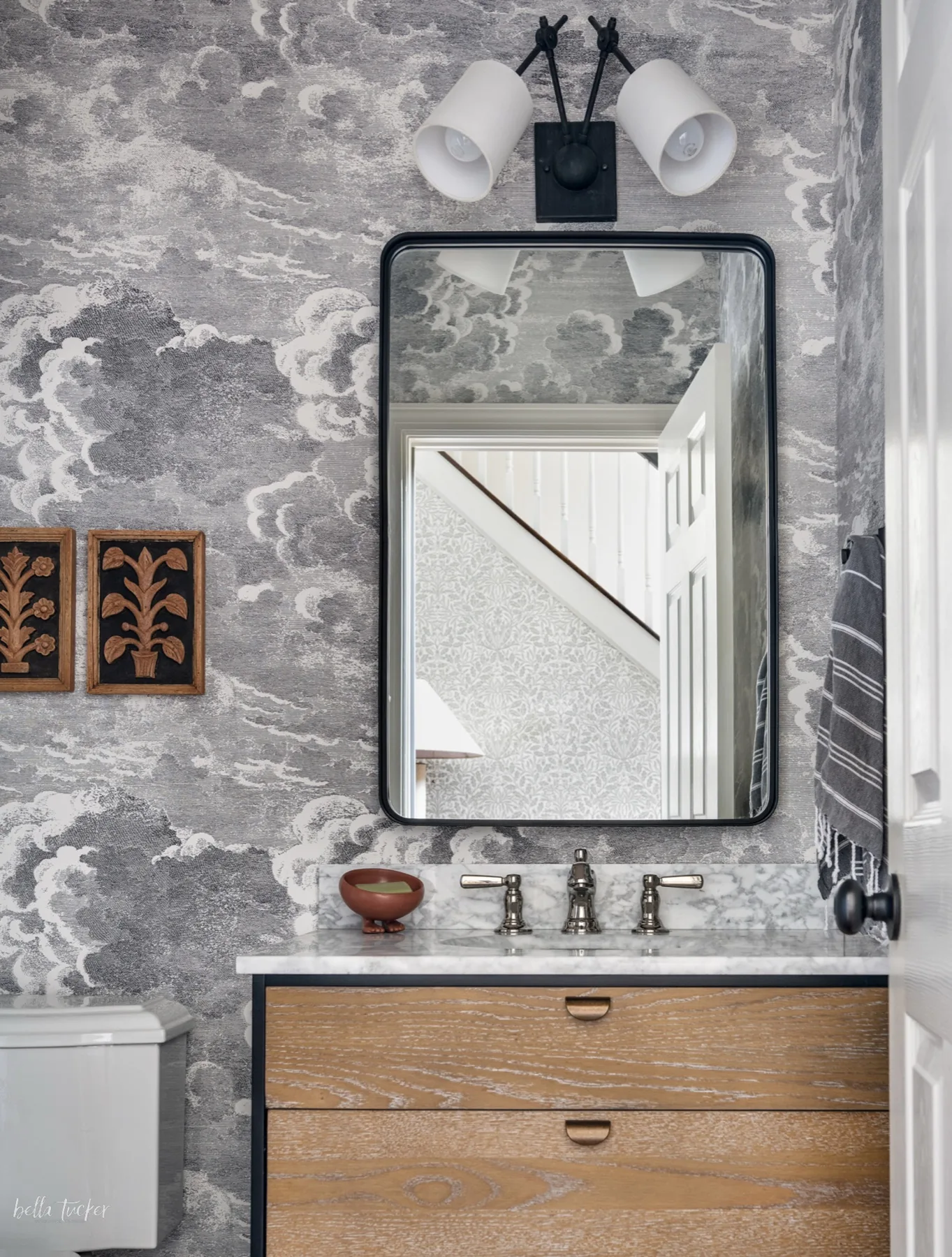 Powder room with cloud wallpaper, marble vanity and styled details