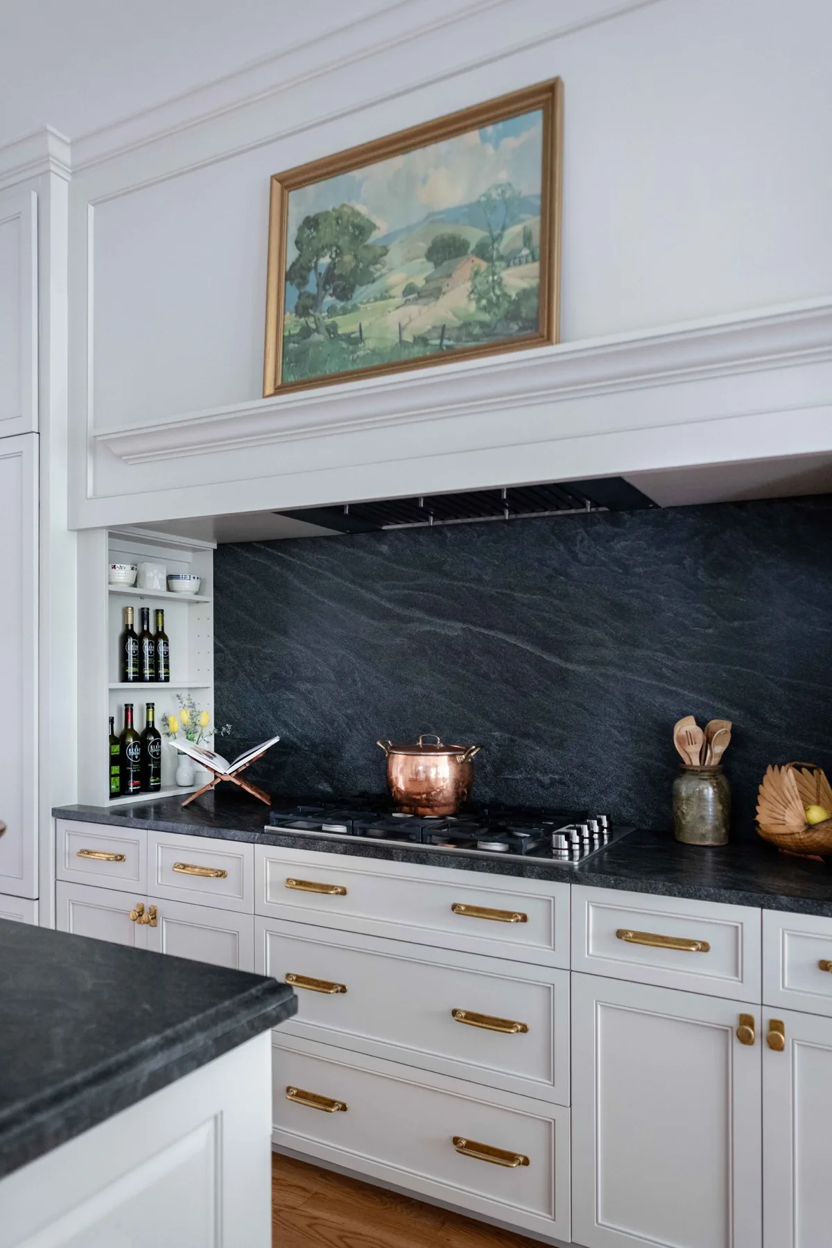 Remodeled kitchen hood alcove with soapstone backsplash and brass hardware